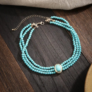 Flerradigt choker-halsband med turkosa pärlor
