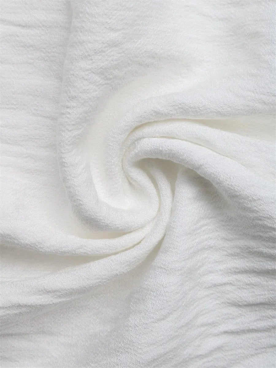 Vit crêppad blus med blommiga applikationer